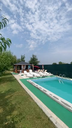 Bazen i uređeno dvorište vikendice sa ležaljkama i senikom